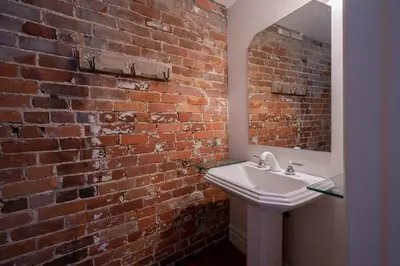a bathroom with a white sink and a brick wall at Exclusive 6 bed, 6 bath residence in Old Montreal in Montréal
