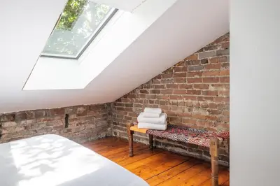 a attic bedroom with a bed and a brick wall at Exclusive 6 bed, 6 bath residence in Old Montreal in Montréal