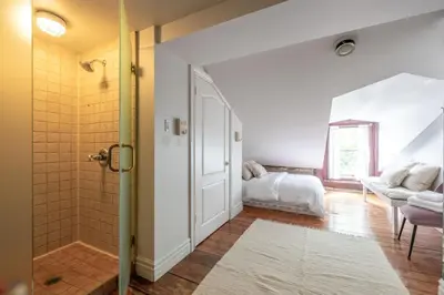 a bathroom with a shower and a bed in a room at Exclusive 6 bed, 6 bath residence in Old Montreal in Montréal