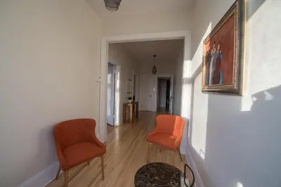 a hallway with two chairs and a painting on a wall at Pignon sur Parc in Trois-Rivières