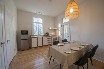 a room with a table with chairs and a kitchen at Pignon sur Parc in Trois-Rivières