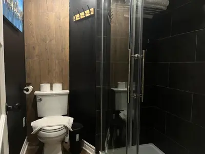 a bathroom with a toilet and a glass shower at Basement 2-bedroom apartment near National Park and Montréal in Saint-Bruno-de-Montarville