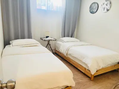 a bedroom with two beds and a clock on the wall at Basement 2-bedroom apartment near National Park and Montréal in Saint-Bruno-de-Montarville