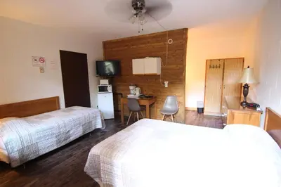 a hotel room with two beds and a desk at Motel Lennoxville in Sherbrooke