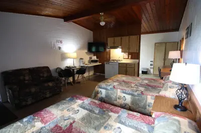 a hotel room with two beds and a living room at Motel Lennoxville in Sherbrooke