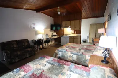 a hotel room with two beds and a living room at Motel Lennoxville in Sherbrooke