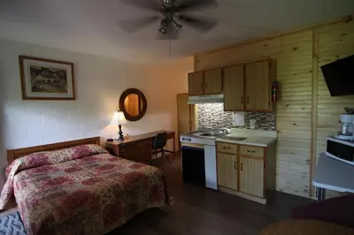 a small bedroom with a bed and a kitchen at Motel Lennoxville in Sherbrooke