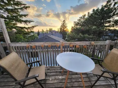 a white table and two chairs on a deck at Cozy 2BR in VieuxLongueuil +parking 14min Downtown in Longueuil