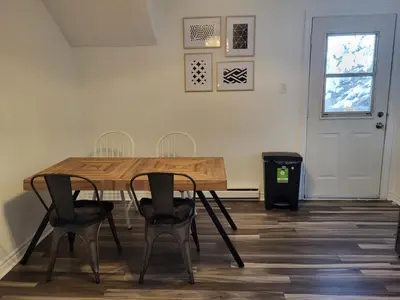a dining room with a wooden table and chairs at Cozy 2BR in VieuxLongueuil +parking 14min Downtown in Longueuil