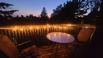 a table and chairs on a wooden deck with lights at Cozy 2BR in VieuxLongueuil +parking 14min Downtown in Longueuil