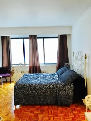 a bedroom with a bed in a room with windows at Stylish Montreal Apartment: Comfortable Stay in the Golden Square Mile in Montréal