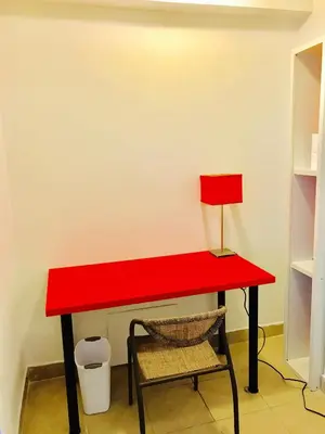 a red desk with a lamp and a chair at Stylish Montreal Apartment: Comfortable Stay in the Golden Square Mile in Montréal