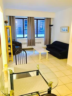 a living room with a couch and a table at Stylish Montreal Apartment: Comfortable Stay in the Golden Square Mile in Montréal