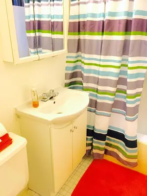 a bathroom with a sink and a shower curtain at Stylish Montreal Apartment: Comfortable Stay in the Golden Square Mile in Montréal