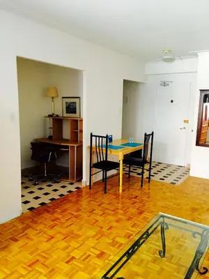 a room with a table and chairs and a piano at Stylish Montreal Apartment: Comfortable Stay in the Golden Square Mile in Montréal