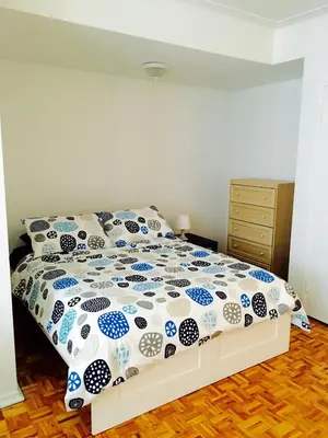 a bedroom with a bed with a blue and white comforter at Stylish Montreal Apartment: Comfortable Stay in the Golden Square Mile in Montréal