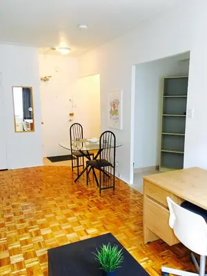 a living room with a table and chairs at Stylish Montreal Apartment: Comfortable Stay in the Golden Square Mile in Montréal