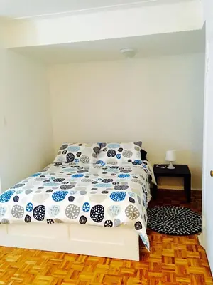 a bedroom with a bed with a blue and white comforter at Stylish Montreal Apartment: Comfortable Stay in the Golden Square Mile in Montréal