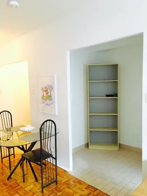 a dining room with a table and chairs and a shelf at Stylish Montreal Apartment: Comfortable Stay in the Golden Square Mile in Montréal