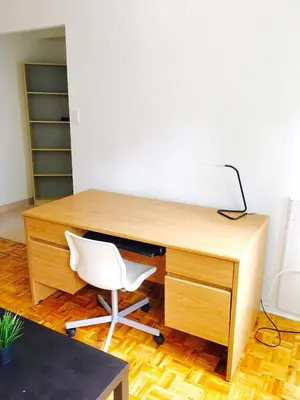 an office with a wooden desk with a white chair at Stylish Montreal Apartment: Comfortable Stay in the Golden Square Mile in Montréal