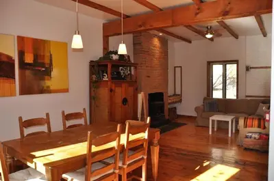 a dining room and living room with a wooden table at Le Tierra del Fuego by HomeInMontreal in Montréal