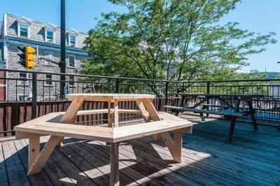 a picnic table and benches on a deck at Le Metro Mont-Royal by HomeInMontreal in Montréal