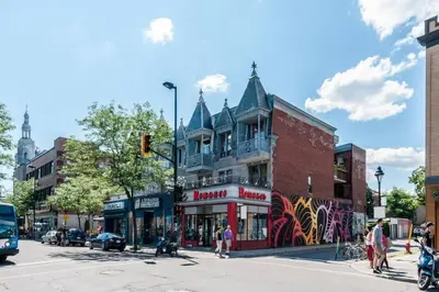 a busy city street with a building on the corner at Le Metro Mont-Royal by HomeInMontreal in Montréal