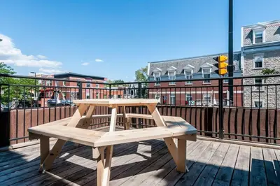 a wooden bench sitting on top of a deck at Le Metro Mont-Royal by HomeInMontreal in Montréal