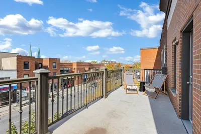 a balcony with two chairs and a building at Lofts de la petite Italie in Montréal