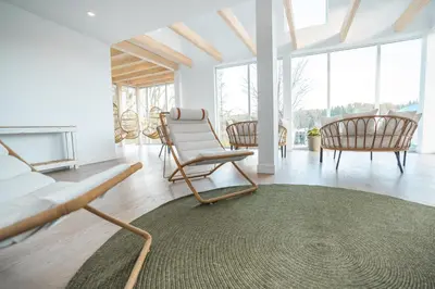 a living room with chairs and a couch and a rug at MiniBora Le beaumier - Cantons-de-l'Est in Bury