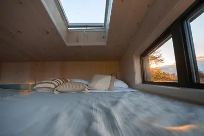 a bedroom with a large bed with a window at MiniBora Le ciel - Cantons-de-l'Est in Bury
