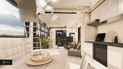 a kitchen and living room with a table at MiniBora Le cumulus - Cantons-de-l'Est in Bury