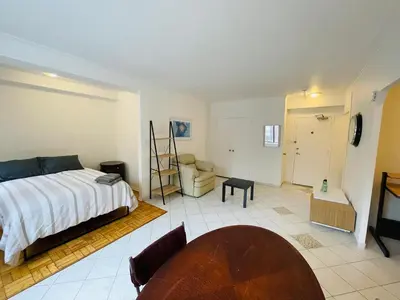 a bedroom with a bed and a chair and a table at Stylish Montreal Apartment: Comfortable Stay in the Golden Square Mile in Montréal