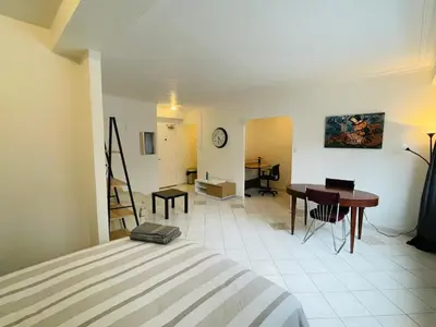 a room with a bed and a desk and a table at Stylish Montreal Apartment: Comfortable Stay in the Golden Square Mile in Montréal
