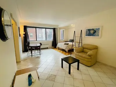 a living room with a couch and a bed at Stylish Montreal Apartment: Comfortable Stay in the Golden Square Mile in Montréal