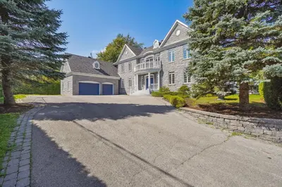 a large white house with a driveway at Private Waterfront Villa 9 BR Peaceful in Laval