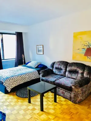 a living room with a couch and a bed at Stylish Montreal Apartment: Comfortable Stay in the Golden Square Mile in Montréal