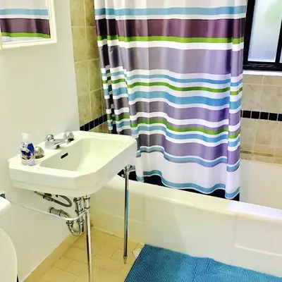 a bathroom with a sink and a shower curtain at Stylish Montreal Apartment: Comfortable Stay in the Golden Square Mile in Montréal