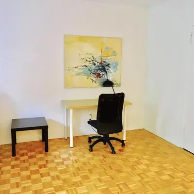 a desk and a chair in a room with a painting at Stylish Montreal Apartment: Comfortable Stay in the Golden Square Mile in Montréal