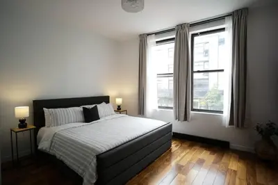 a bedroom with a large bed and two windows at HRésidences Modern Condo on MAIN St Laurent Blvd in Montréal