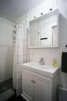 a white bathroom with a sink and a mirror at HRésidences Modern Condo on MAIN St Laurent Blvd in Montréal
