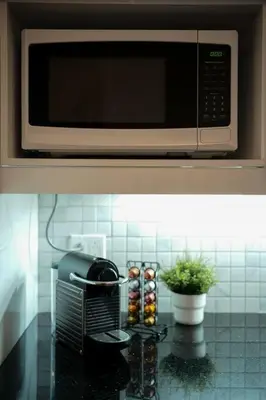 a microwave above a kitchen counter with muffins at HRésidences Modern Condo on MAIN St Laurent Blvd in Montréal