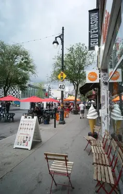 a city street with benches and tables and umbrellas at HRésidences Modern Condo on MAIN St Laurent Blvd in Montréal