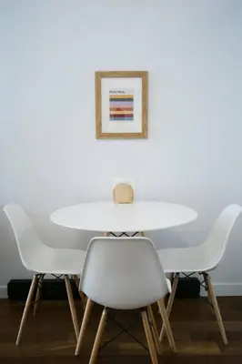 a white table with two white chairs and a picture at HRésidences Modern Condo on MAIN St Laurent Blvd in Montréal