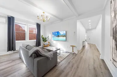 a living room with a couch and a chandelier at Modern and cozy 4 bedrooms sleep 12 in Montréal