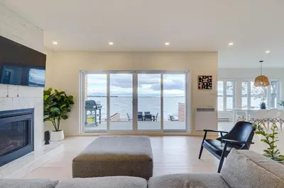 a living room with a couch and a fireplace at Modern Lake Champlain Villa with Spa in Venise-en-Québec