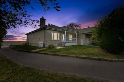 a house on a street with a sunset at Modern Lake Champlain Villa with Spa in Venise-en-Québec