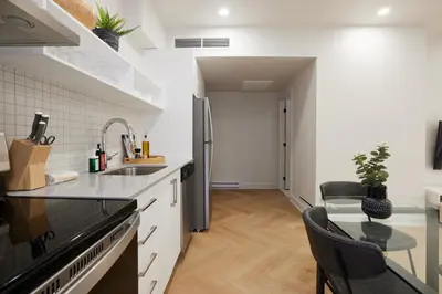 a kitchen with a stainless steel refrigerator and a table at Chic 2 Bedroom apartment in Le Plateau by Denstays in Montréal