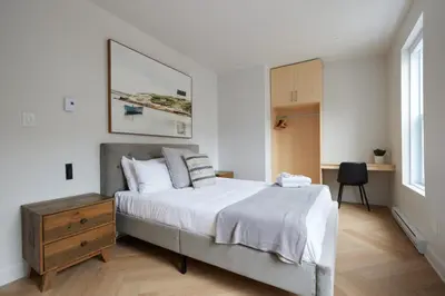 a bedroom with a large bed and a wooden dresser at Chic 2 Bedroom apartment in Le Plateau by Denstays in Montréal