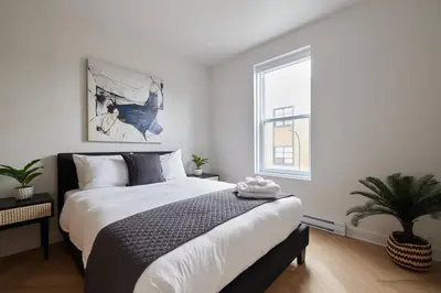 a bedroom with a large bed and a window at New and Cozy 3 bedroom in Le Plateau by Denstays in Montréal